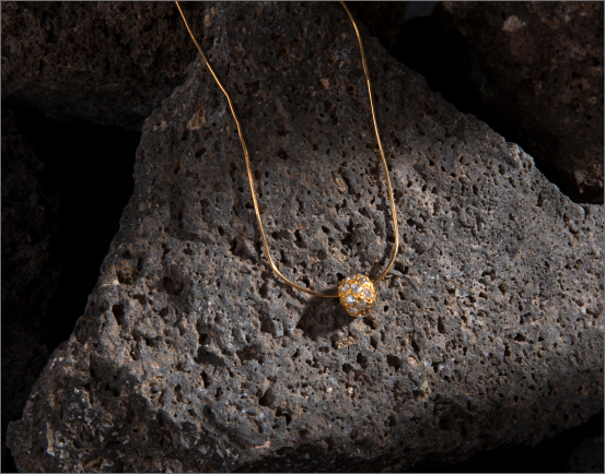 Gold necklace on volcanic rock